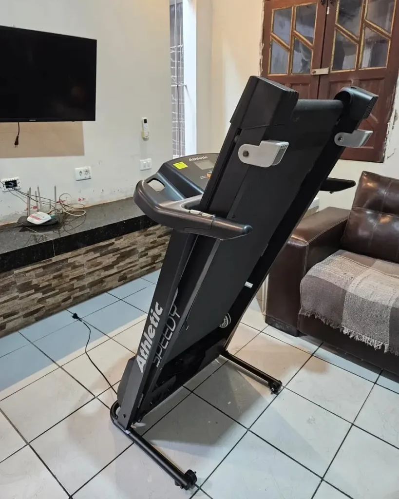 Close no painel de controle da esteira Athletic Speedy com chave de segurança amarela em destaque.